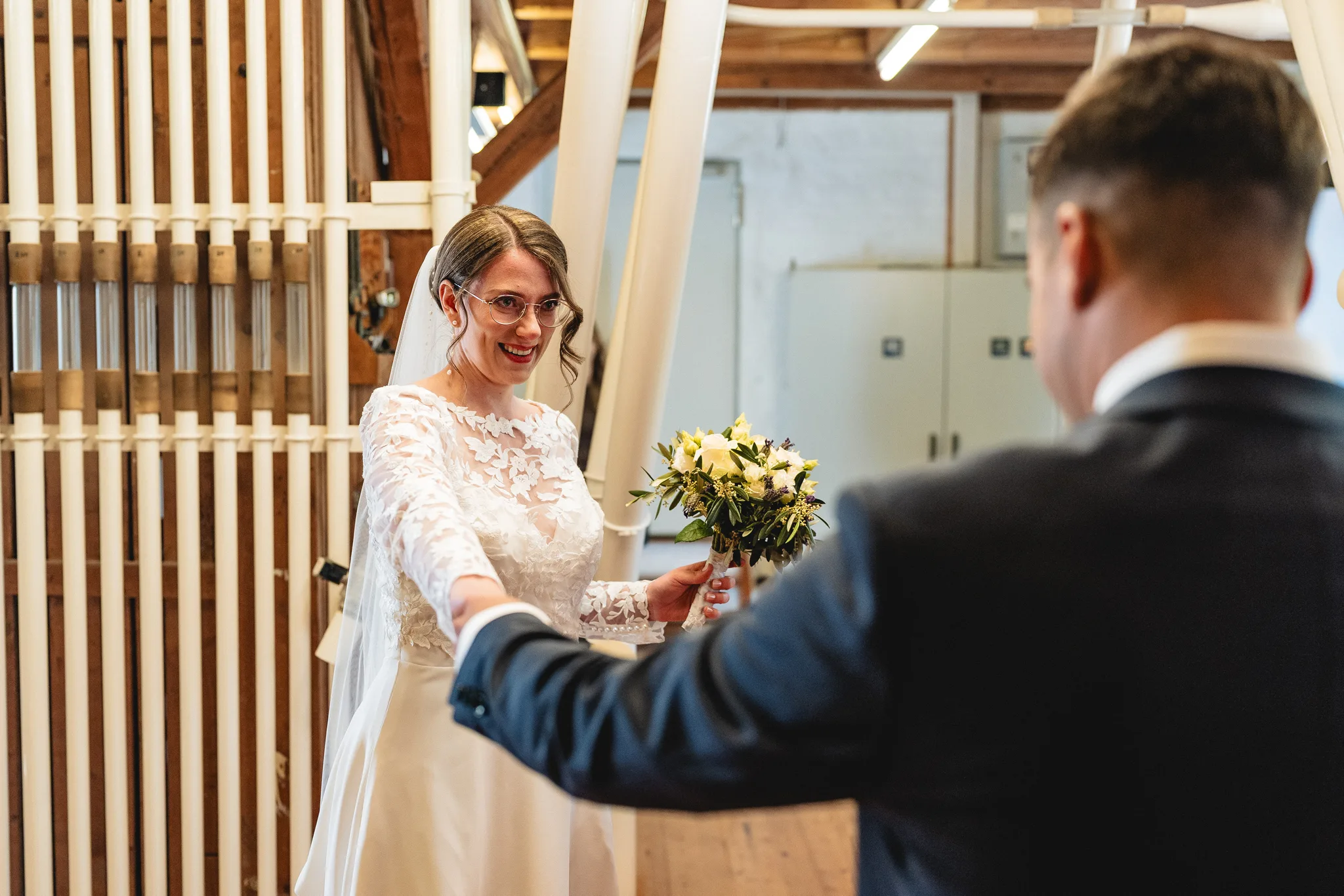 Stefanie und Ralf halten sich beim emotionalen First Look in der historisch restaurierten Ulstermühle an den Händen.